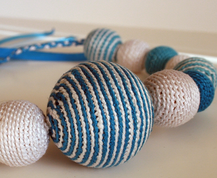 Бело-голубые бусы с погремушкой.